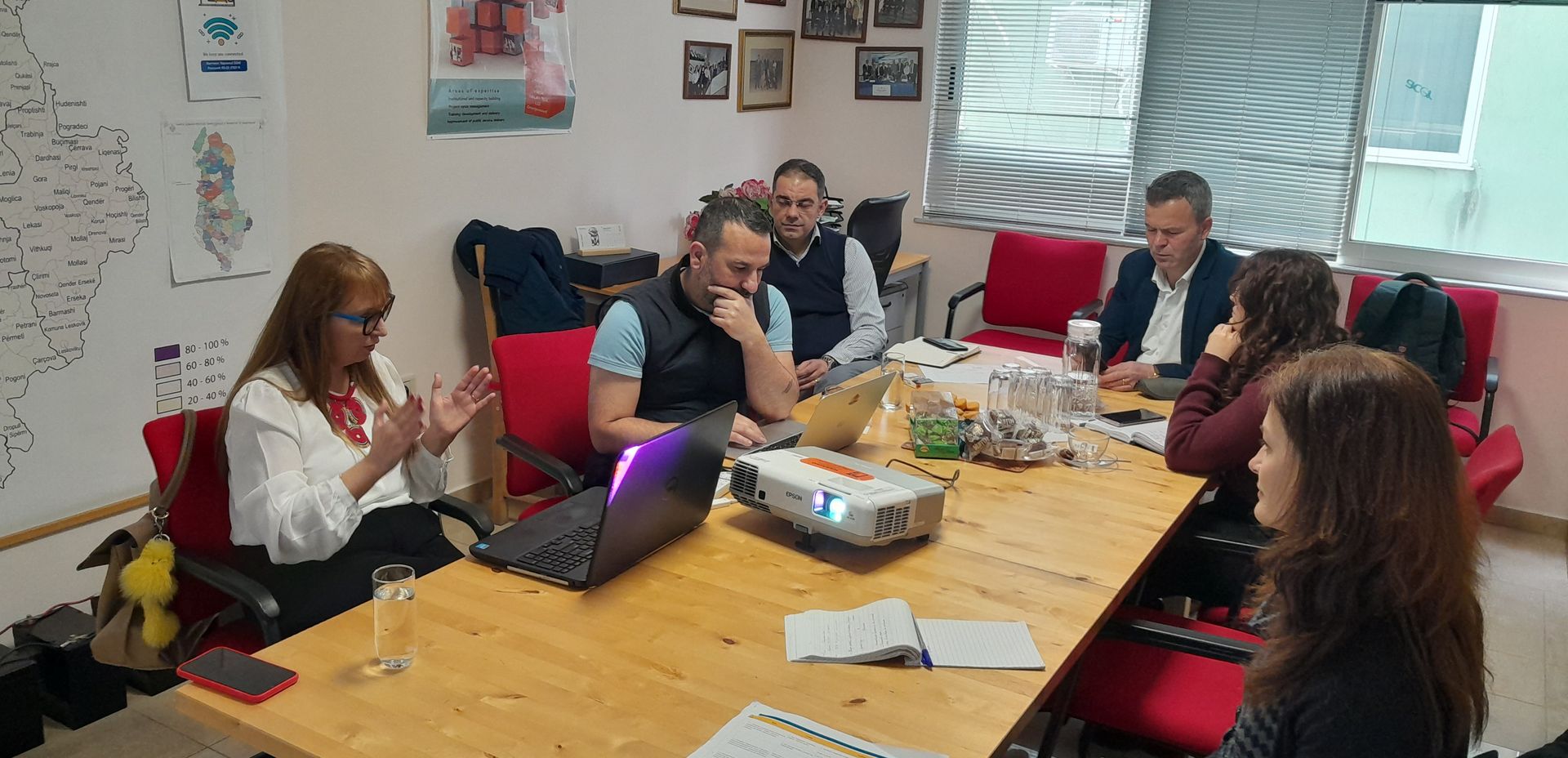 Regional planning meeting with a map of Albania's municipalities