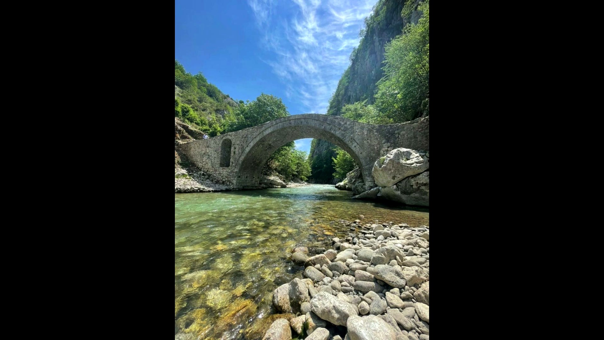 Historic stone arch bridge over Albanian river